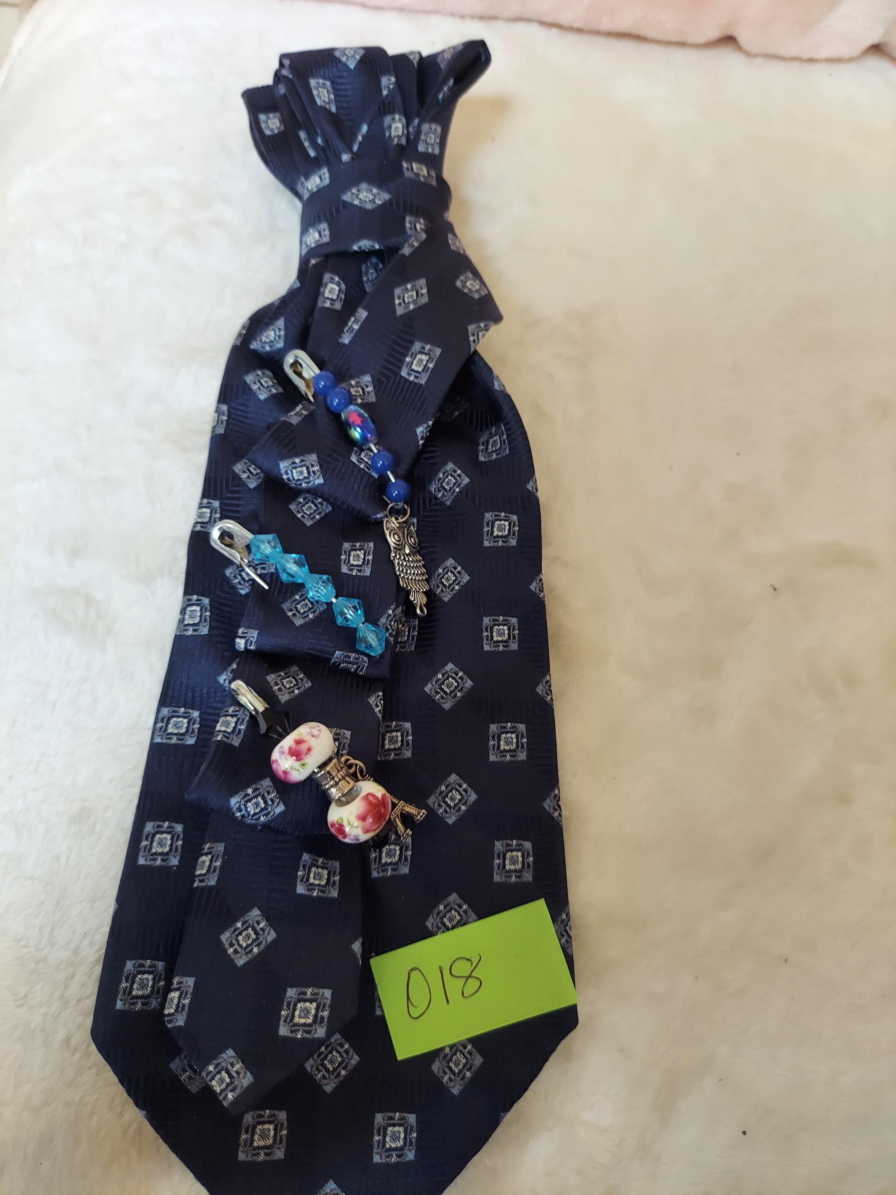 Navy patterned necktie with decorative charms